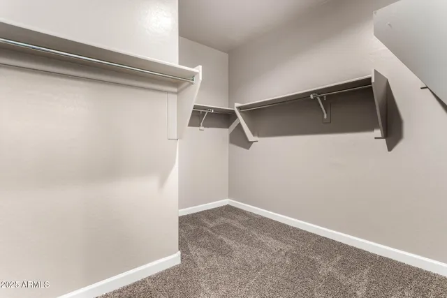 a view of walk in closet with empty racks