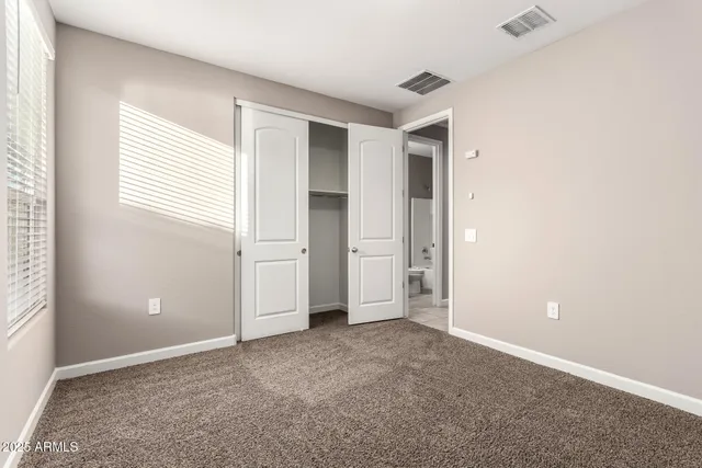 an empty room with windows and closet
