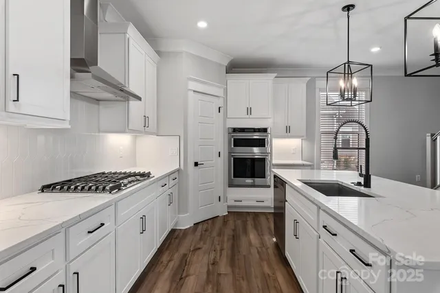 a kitchen with granite countertop a sink stove and cabinets