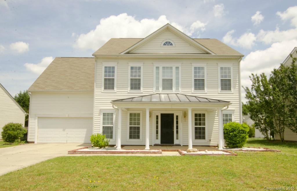front view of a brick house with a yard