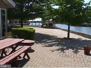 1 Club House Road Brick, NJ 08723 - Photo 5 of 6 a view of a patio with table and chairs a fire pit and a lawn chairs