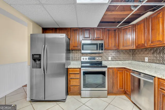 a kitchen with stainless steel appliances granite countertop a refrigerator and a stove