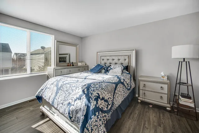 a bedroom with a bed and a large window