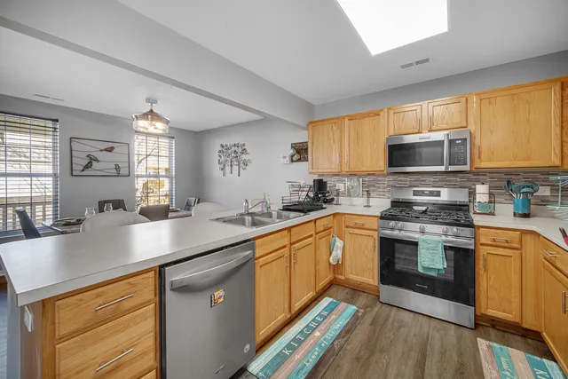 a kitchen with stainless steel appliances granite countertop a sink stove and microwave