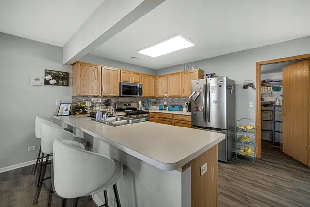 a kitchen with kitchen island a refrigerator stove microwave and cabinets