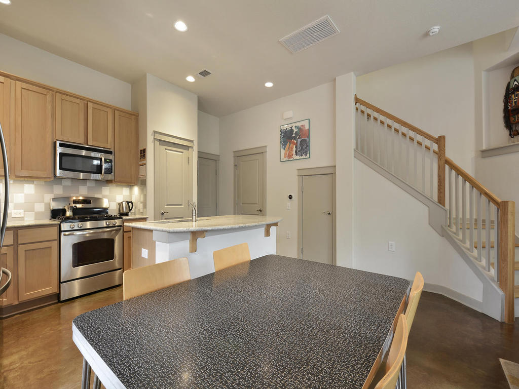 3900 Threadgill Street, Unit 32 Austin, TX 78723 - Photo 13 of 30 Stained concrete floors and clean lines define this modern open kitchen and dining area.