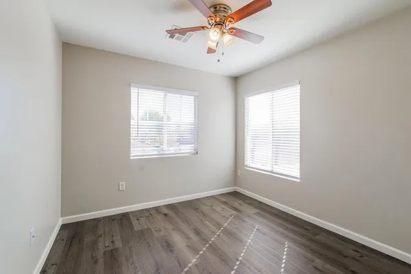 an empty room with a window and a fan