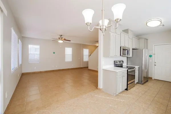 a view of a kitchen with a sink and dishwasher a refrigerator with white cabinets