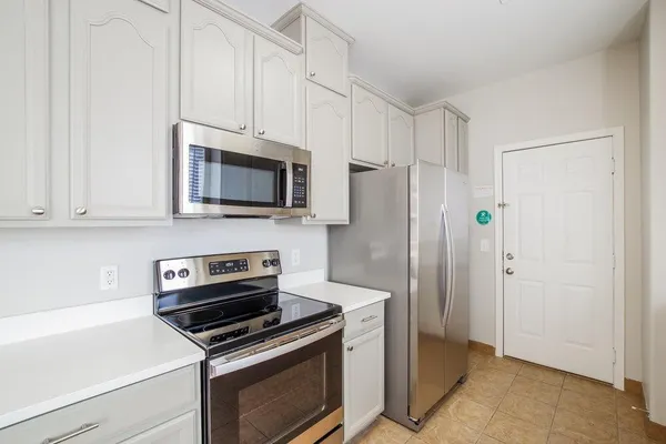 a kitchen with stainless steel appliances a stove a microwave and a white cabinets