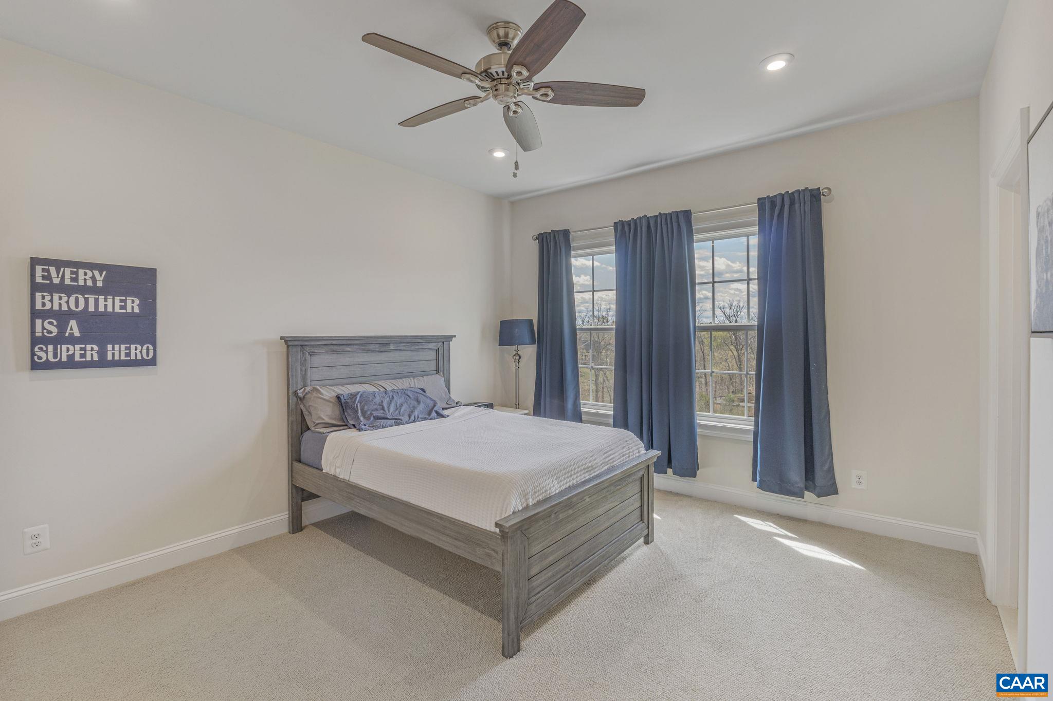 3624 Osprey Drive Keswick, VA 22947 - Photo 45 of 68 a bedroom with a large bed and a chandelier