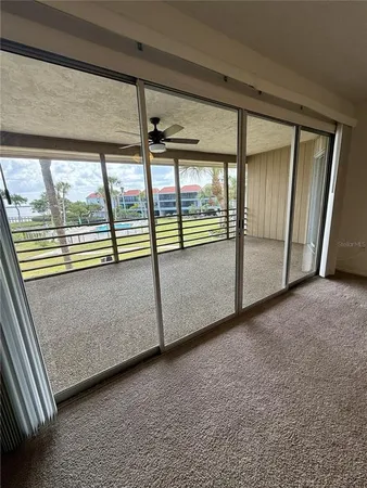 a view of a big room with windows and chandelier fan