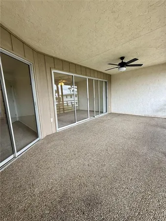 an empty room with chandelier fan and closet area