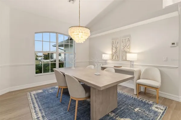 a living room with furniture a large window and a chandelier