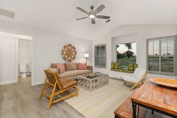 a living room with furniture and a view of kitchen