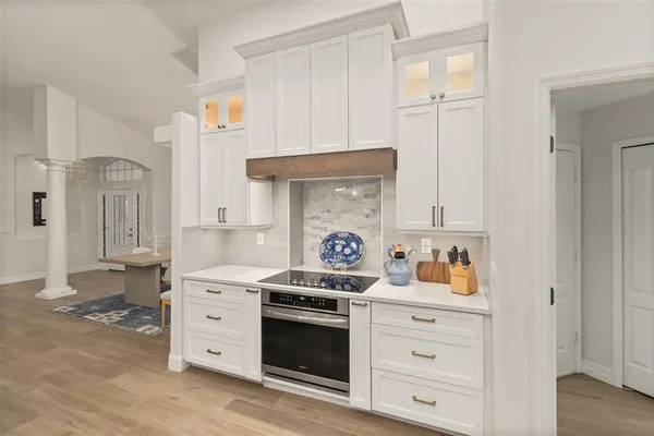 a kitchen with white cabinets and refrigerator