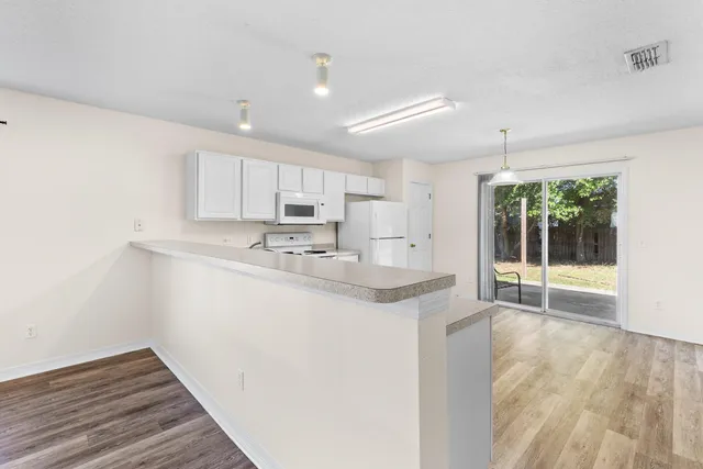 a kitchen with kitchen island a sink a stove a refrigerator cabinets and a window