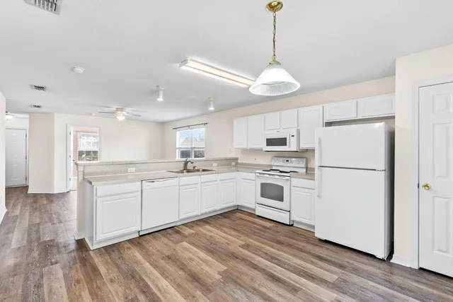 a kitchen with white cabinets and white appliances