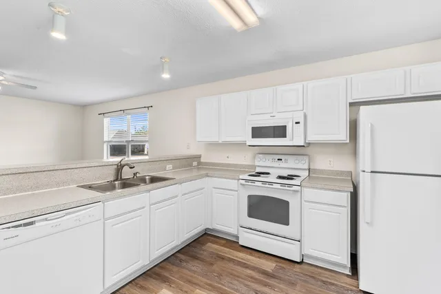 a kitchen with white cabinets and white appliances