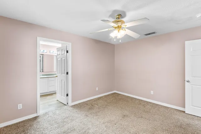 an empty room with closet and a chandelier fan