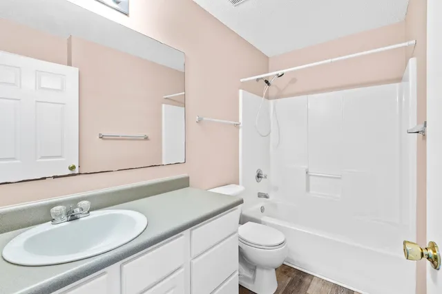 a bathroom with a granite countertop sink toilet and shower