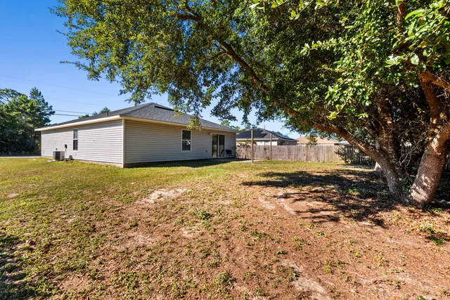 a view of house with swimming pool outdoor seating and house in the background