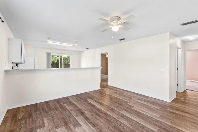 a view of an empty room with wooden floor
