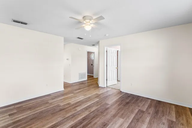 a view of an empty room with wooden floor