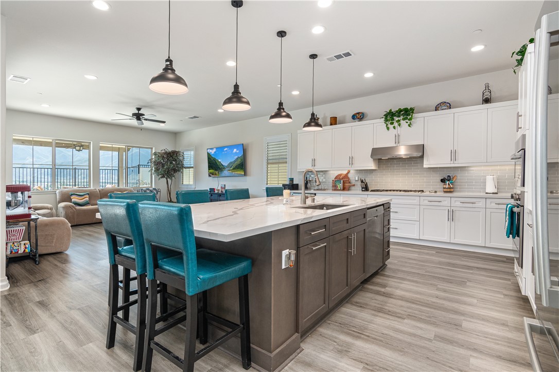 11523 Explorer Court Corona, CA 92883 - Photo 6 of 64 a large kitchen with stainless steel appliances kitchen island a large island in the center