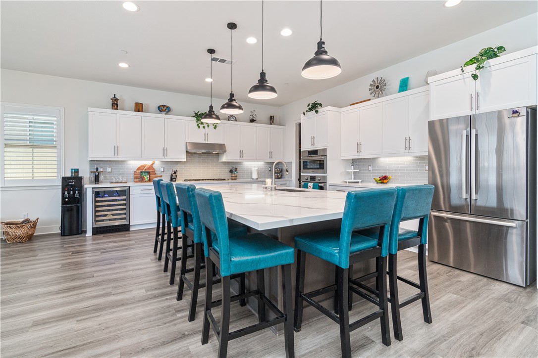 11523 Explorer Court Corona, CA 92883 - Photo 7 of 64 a kitchen with stainless steel appliances kitchen island granite countertop a dining table chairs and a refrigerator
