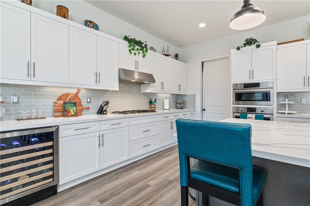 11523 Explorer Court Corona, CA 92883 - Photo 8 of 64 a kitchen with stainless steel appliances a white table chairs and a refrigerator