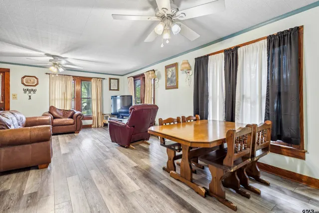 a living room with furniture a large window and wooden floor