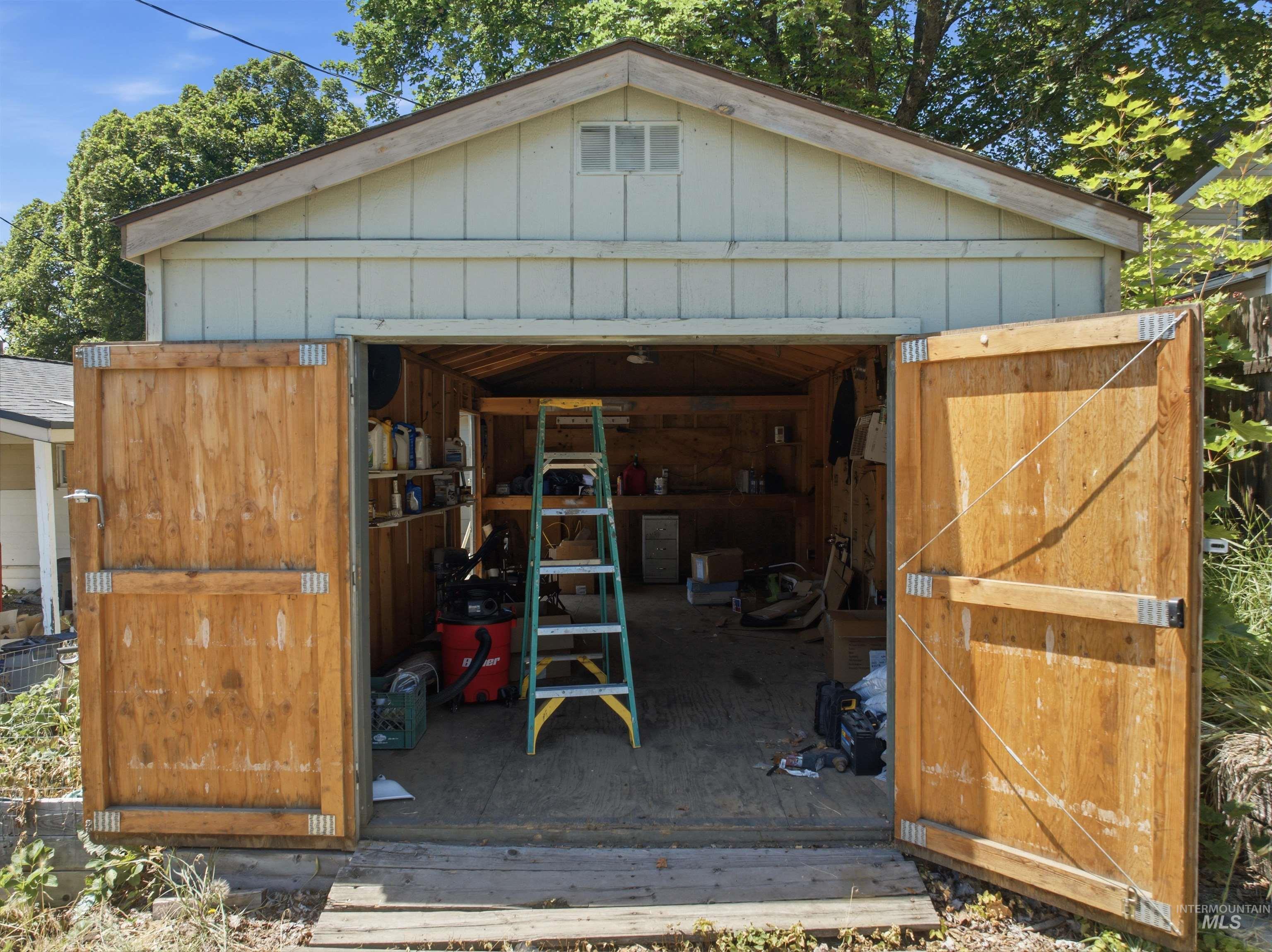 735 Oak Street Potlatch, ID 83855 - Photo 16 of 30 Detached garage with light-toned siding, a brown shingled roof, and a gable vent