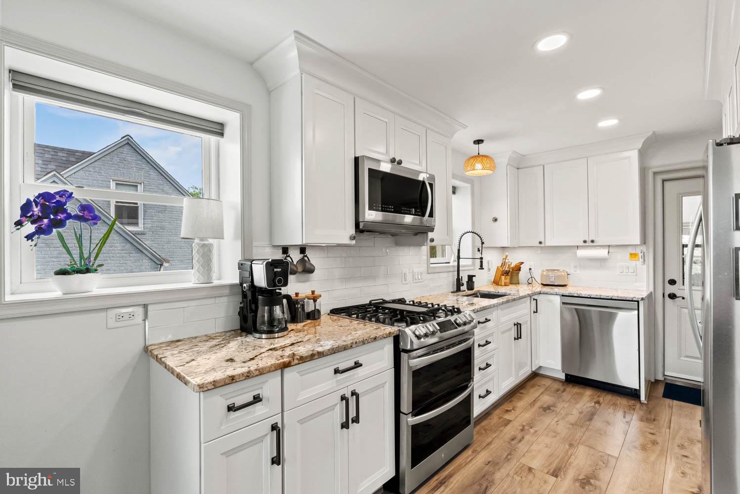 819 Chillum Road Hyattsville, MD 20783 - Photo 6 of 48 a kitchen with kitchen island granite countertop a sink appliances cabinets and a counter top space