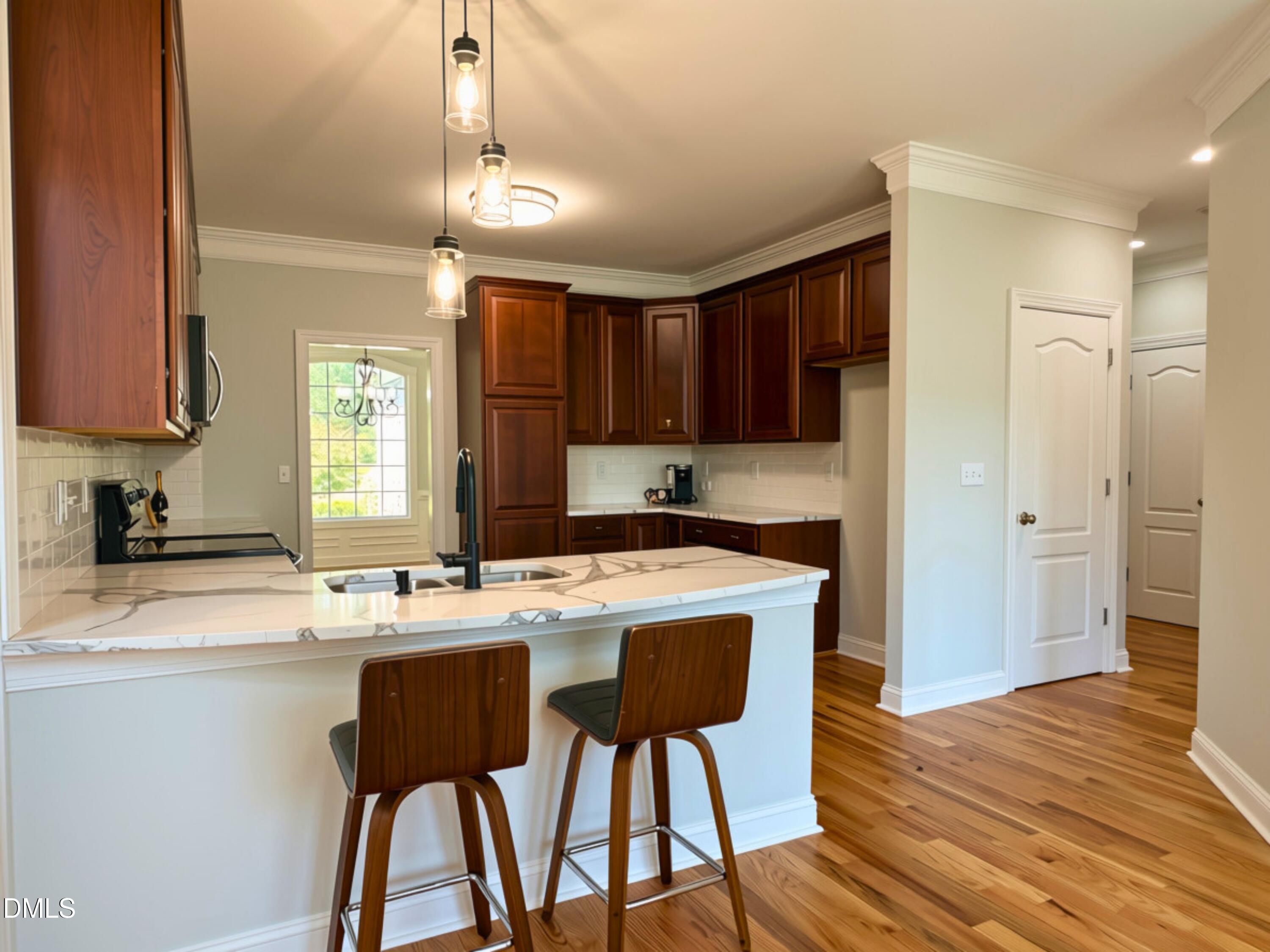 3100 Donlin Drive Wake Forest, NC 27587 - Photo 18 of 67 Kitchen featuring rich wood cabinetry, stone countertops, a tile backsplash, and a breakfast bar