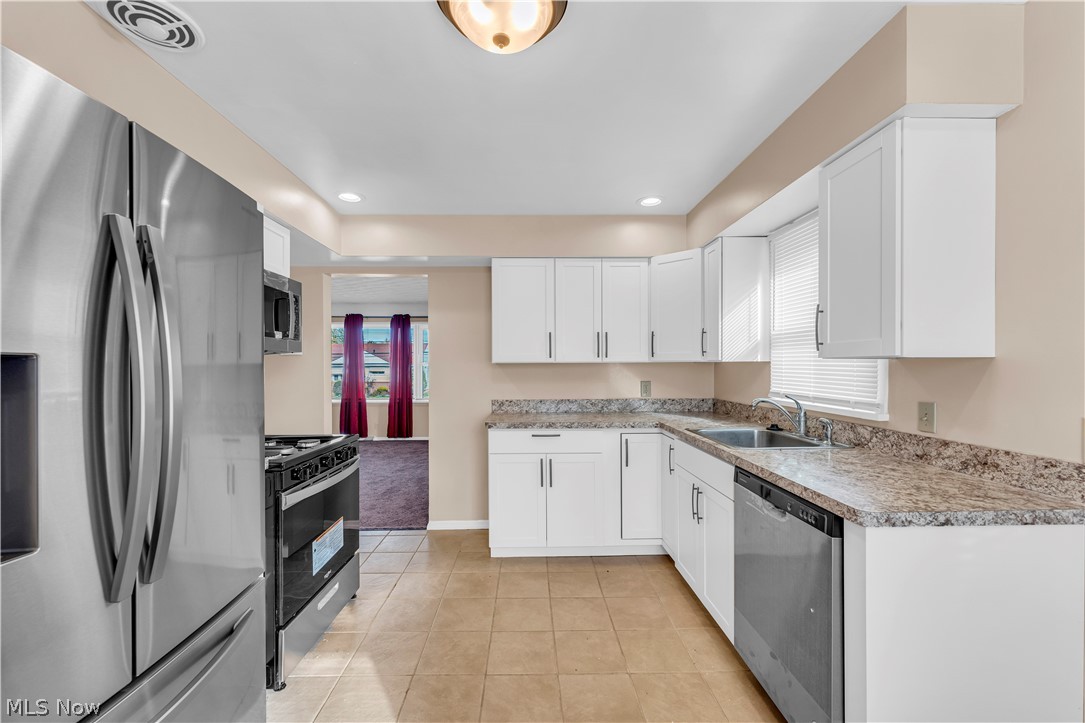 9716 Alexander Road Cleveland, OH 44125 - Photo 6 of 30 Kitchen with stainless steel appliances, white cabinetry, plenty of natural light, and recessed lighting