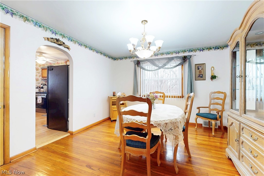 391 Canton Road Steubenville, OH 43953 - Photo 9 of 40 Dining room with arched walkways, a chandelier, and light wood-type flooring
