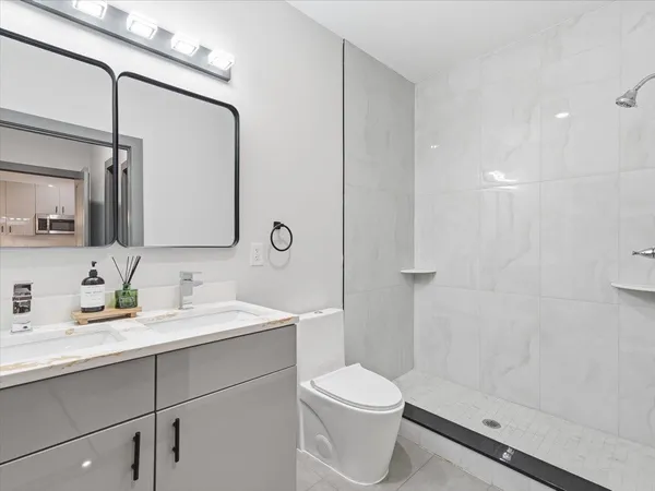 a bathroom with a sink a toilet and shower