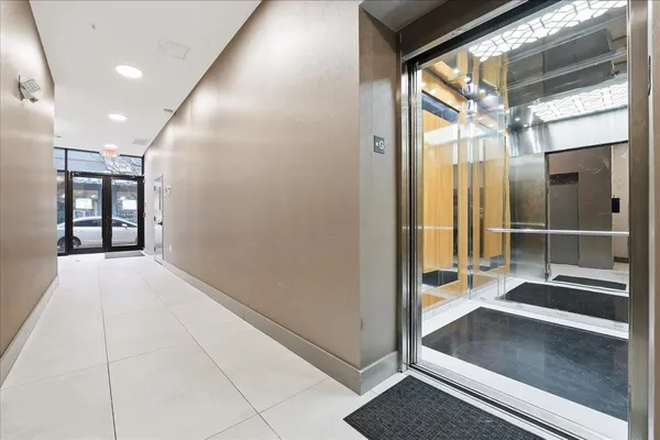 a view of a hallway with windows and chandelier