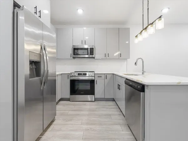 a kitchen with stainless steel appliances a stove sink and refrigerator