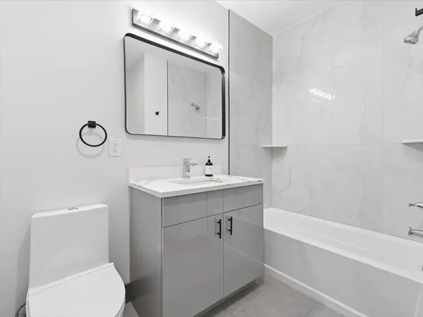 a bathroom with a sink mirror vanity and toilet