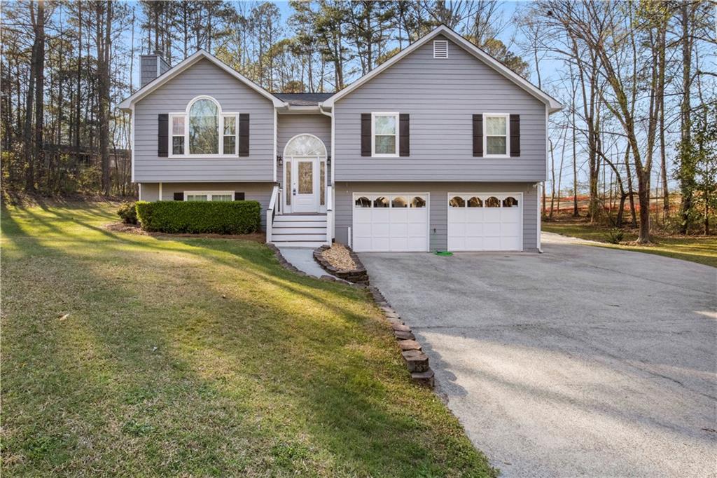 3852 Riding Woods Court Powder Springs, GA 30127 - Photo 1 of 1 a front view of a house with a yard and garage
