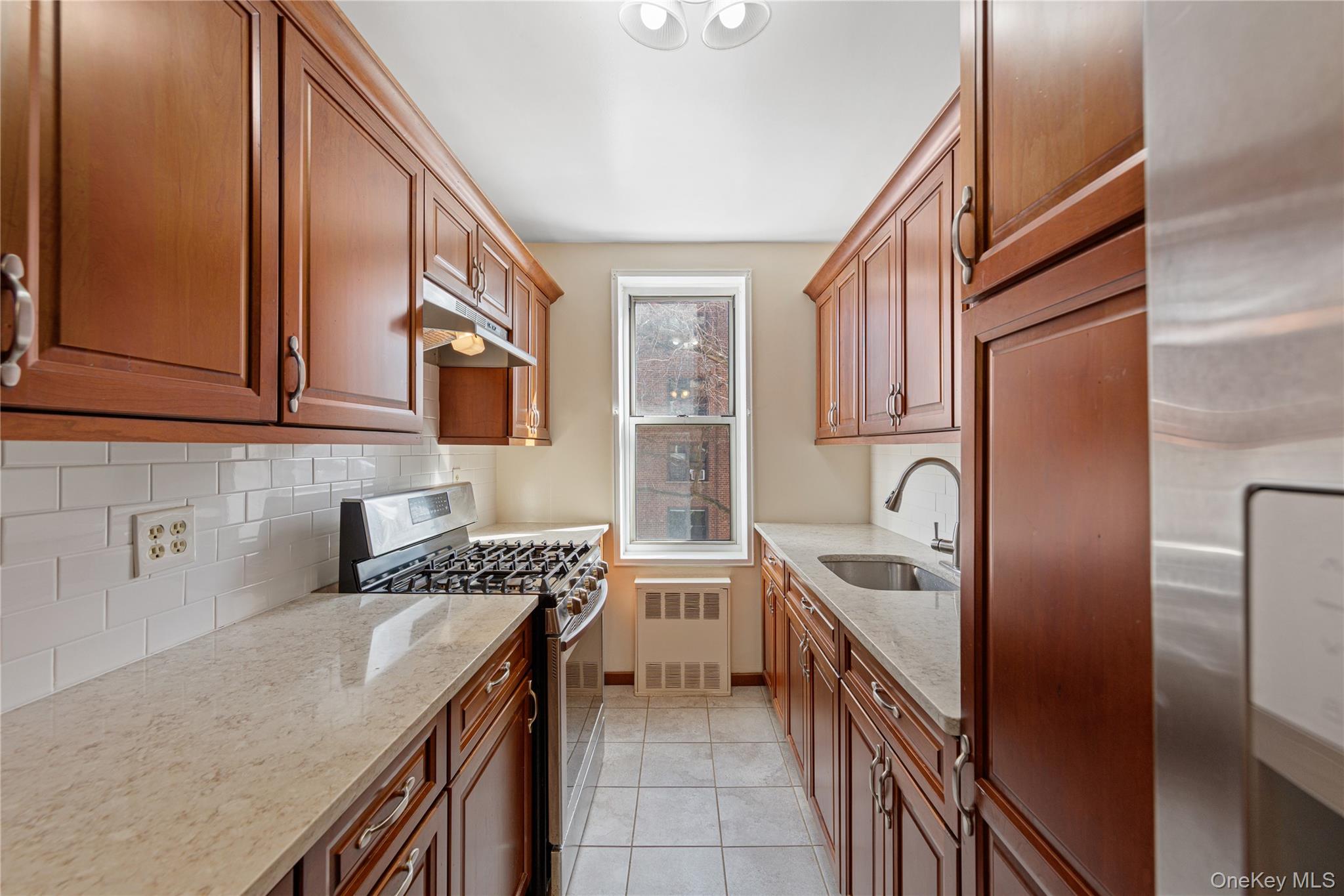 126 Church Street, Unit 2D New Rochelle, NY 10805 - Photo 18 of 32 a kitchen with stainless steel appliances granite countertop a sink stove and cabinets