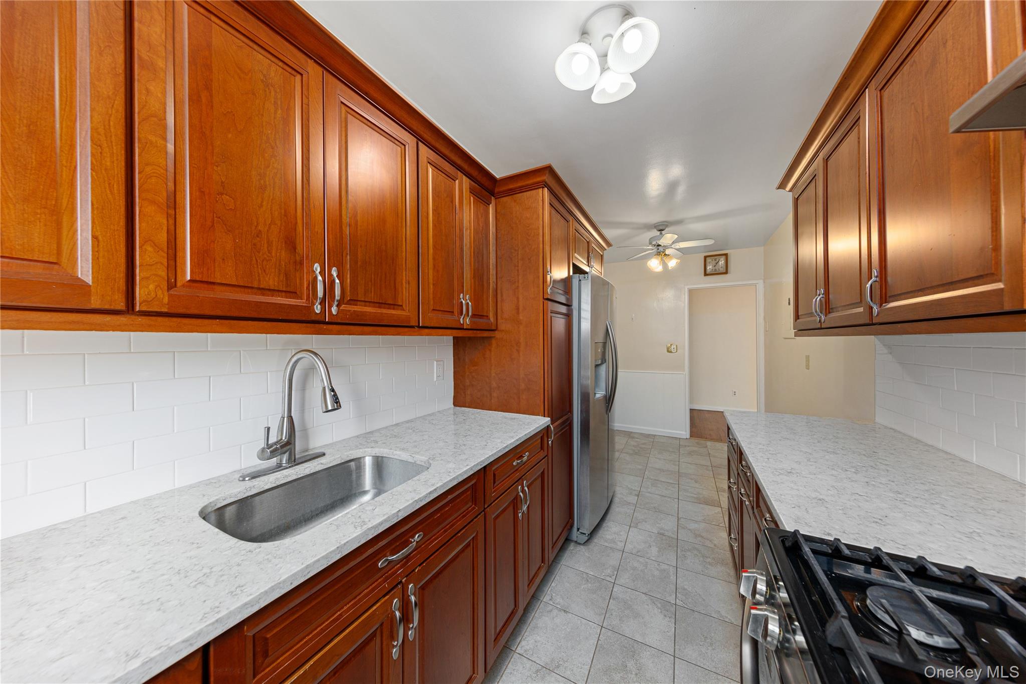 126 Church Street, Unit 2D New Rochelle, NY 10805 - Photo 19 of 32 a kitchen with stainless steel appliances granite countertop a sink and a refrigerator