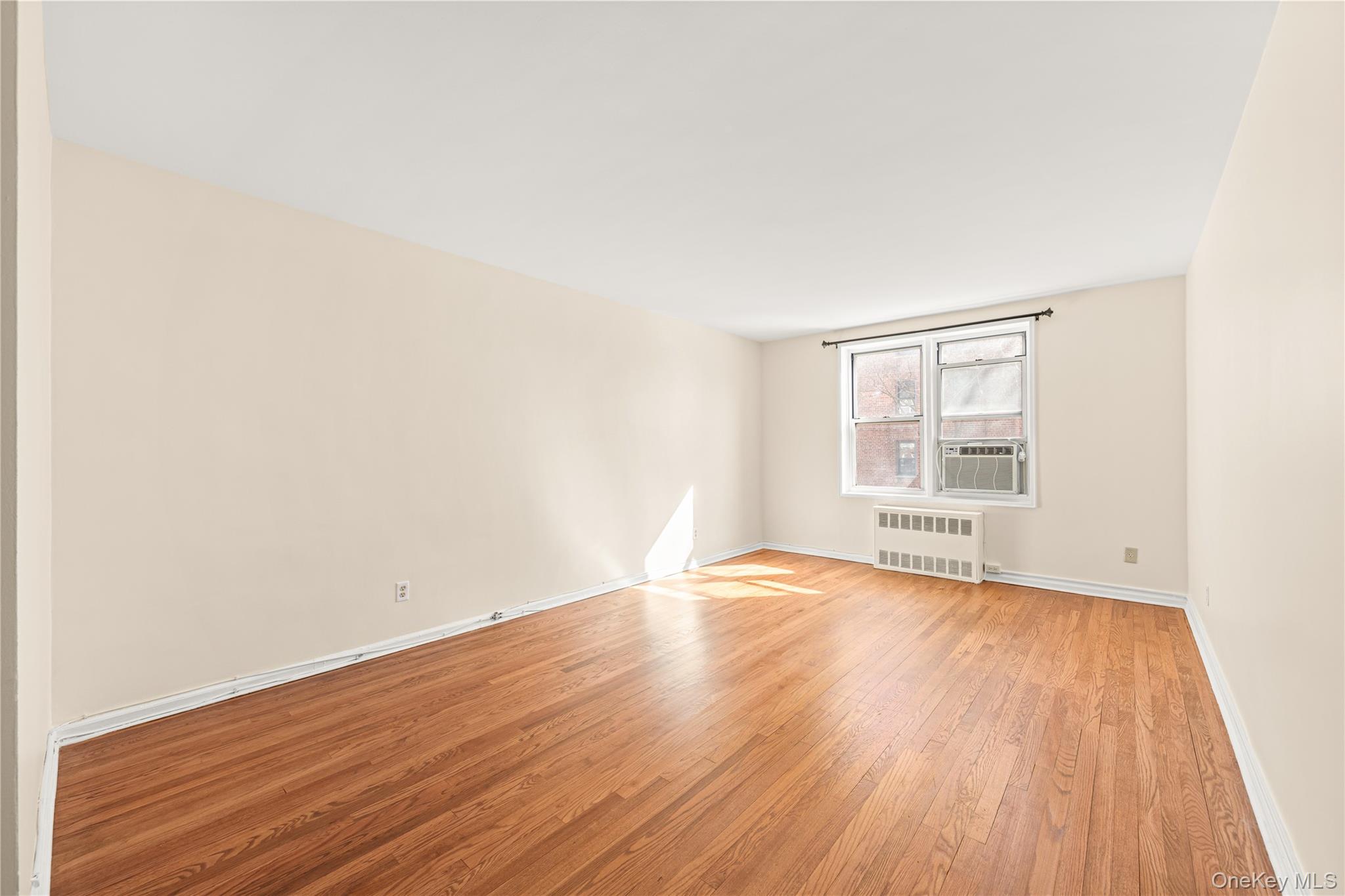 126 Church Street, Unit 2D New Rochelle, NY 10805 - Photo 4 of 32 an empty room with wooden floor and windows