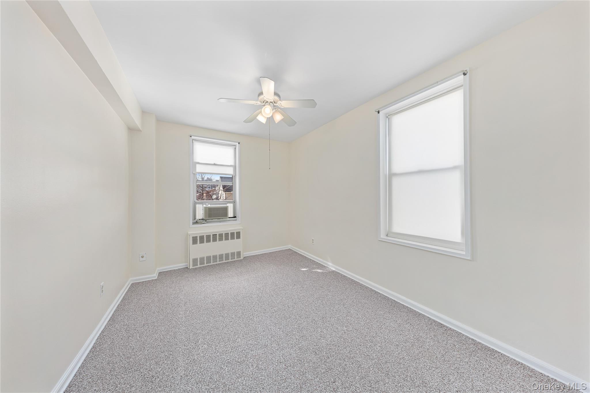 126 Church Street, Unit 2D New Rochelle, NY 10805 - Photo 8 of 32 an empty room with windows and fan