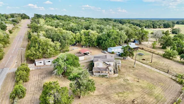 an aerial view of a house with a yard and lake view