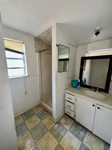 a kitchen with white cabinets and sink