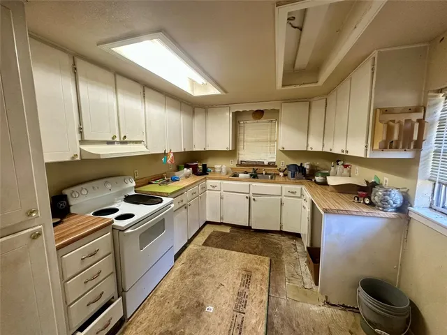 a kitchen with cabinets appliances and a window