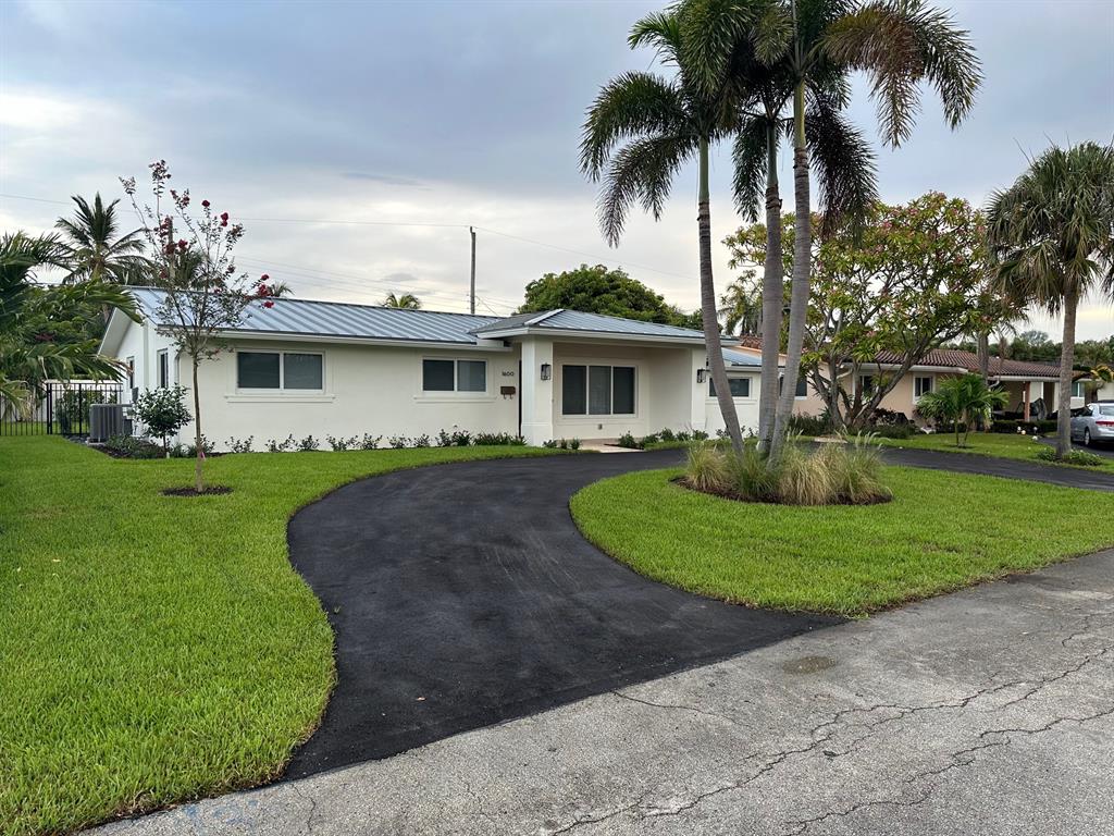 1600 Northeast 59th Place Fort Lauderdale, FL 33334 - Photo 1 of 2 a front view of a house with a garden and trees