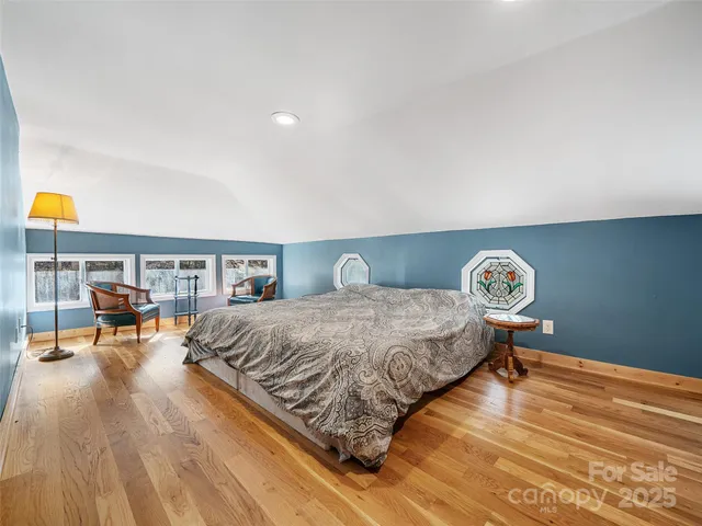 a view of empty room with window and wooden floor